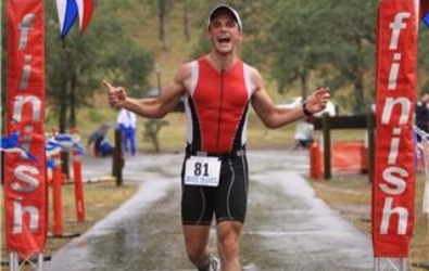 Male athlete approaches triathlon finish line